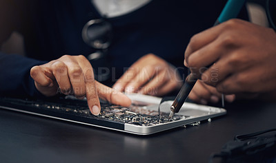 Buy stock photo Shot of two technicians repairing a laptop together