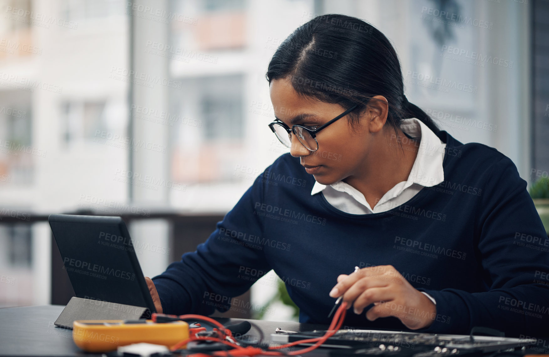 Buy stock photo Shot of a young technician using a digital tablet while repairing computer hardware