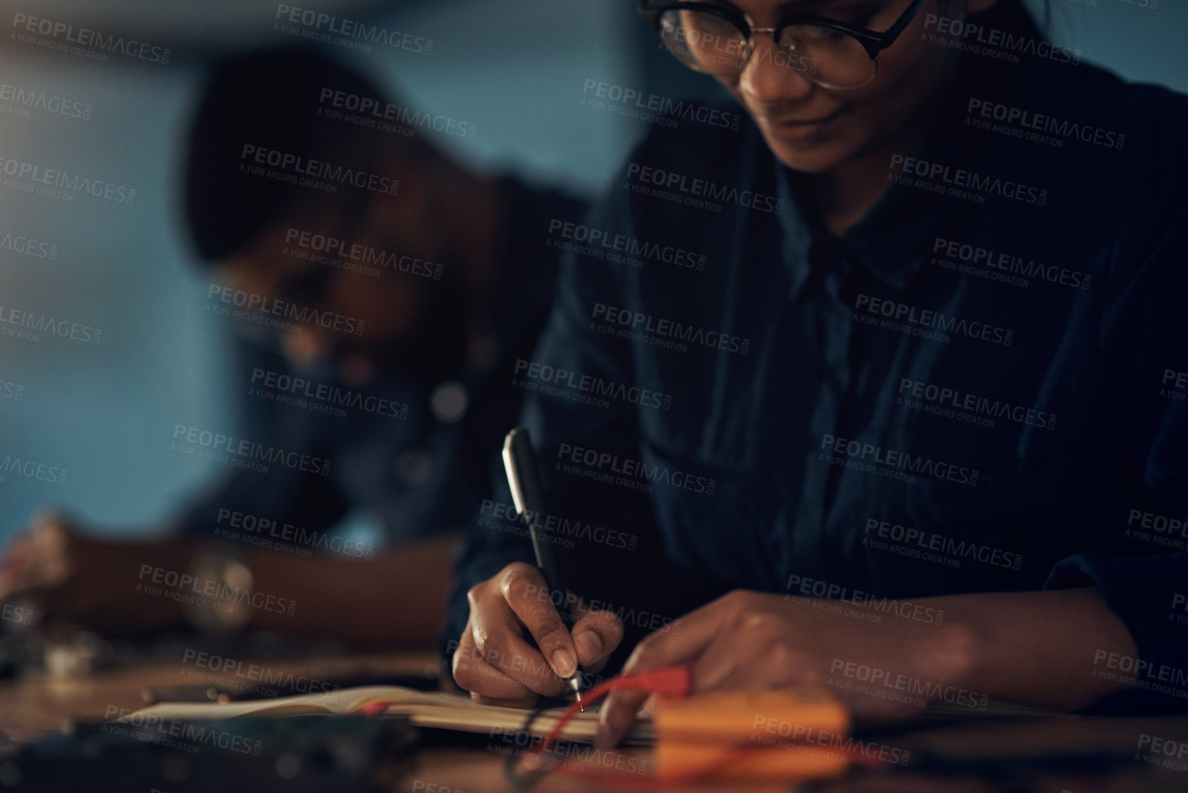Buy stock photo Shot of a young technician writing in a notebook while repairing computer hardware
