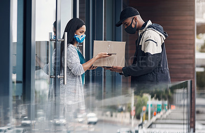 Buy stock photo Shot of a masked young man and woman using smartphones during a home delivery