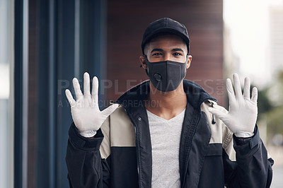 Buy stock photo Shot of a masked young man gesturing with his gloved hands while making a home delivery