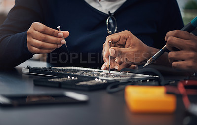 Buy stock photo Shot of two technicians repairing a laptop together