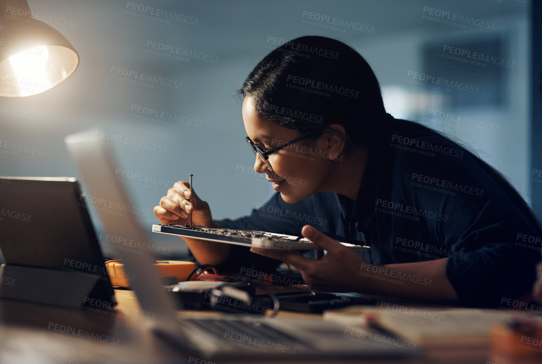 Buy stock photo Shot of a young technician using a screwdriver to repair computer hardware