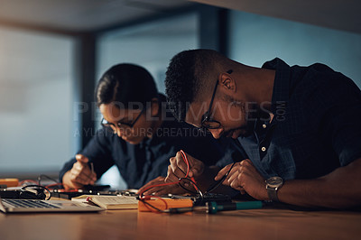Buy stock photo Shot of two young technicians repairing computer hardware together