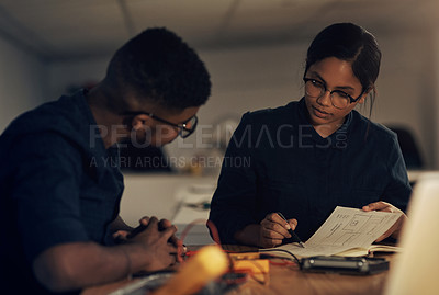 Buy stock photo Shot of two young technicians having a discussion while repairing computer hardware