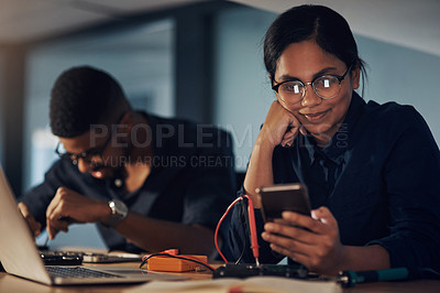 Buy stock photo Shot of a young technician using a smartphone while repairing computer hardware