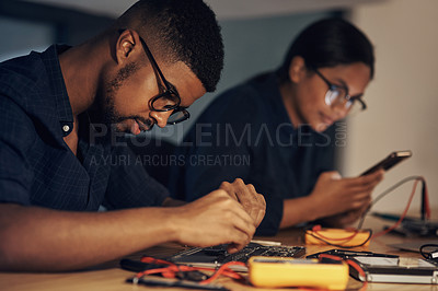 Buy stock photo Shot of two young technicians repairing computer hardware together