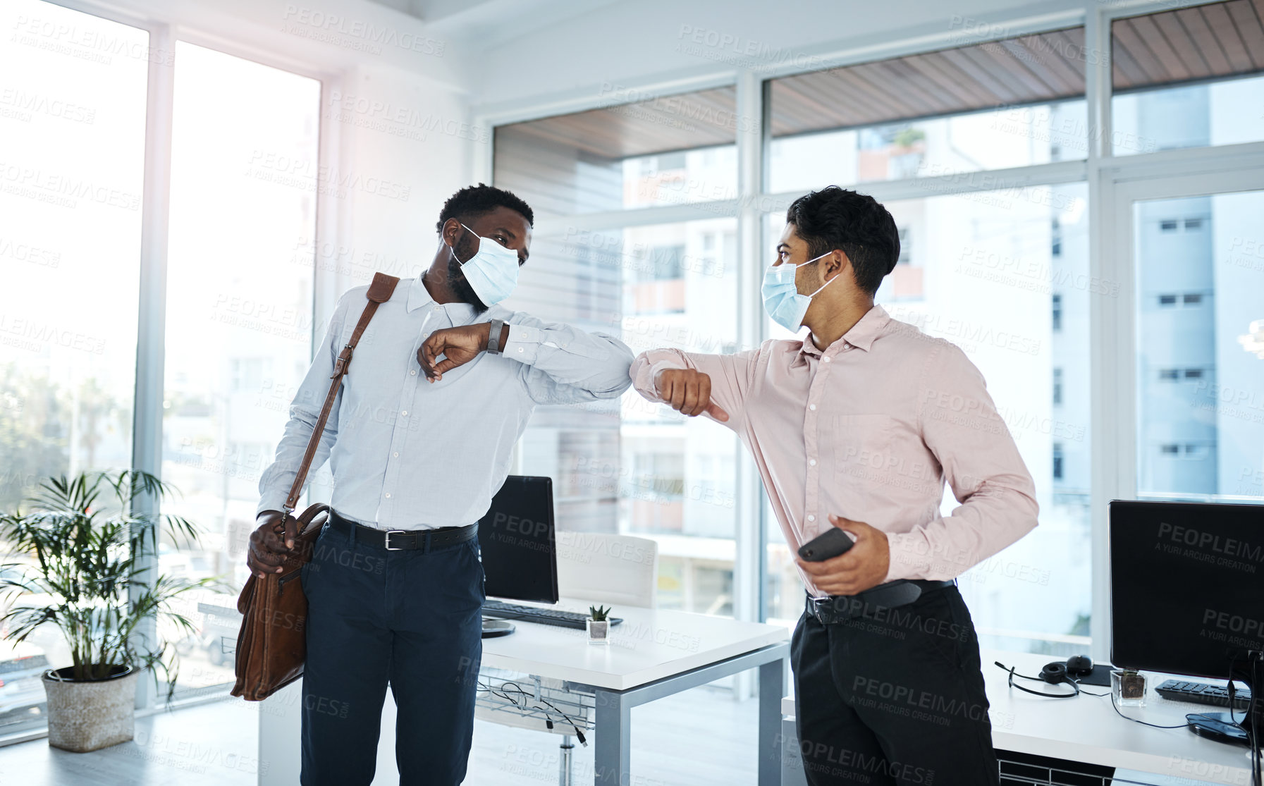 Buy stock photo Shot of two businessmen bumping elbows in an office