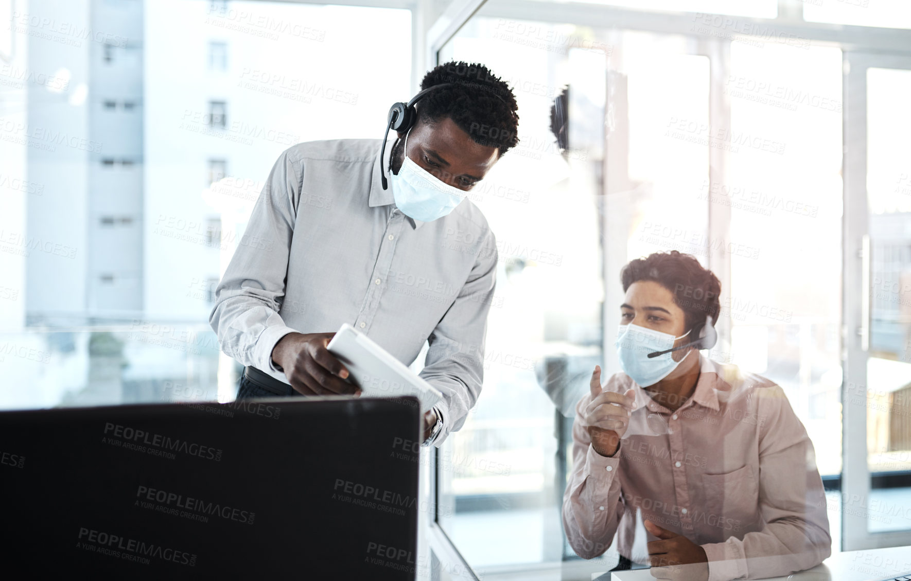 Buy stock photo Shot of two call centre agents working together in an office