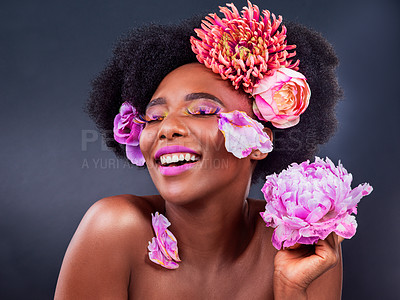 Buy stock photo African, girl and beauty with flowers, smile and confidence for makeup, skincare and wellness in studio. Female person, pose and happy for fashion, style and luxury in grey background for cosmetics