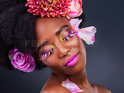Buy stock photo African, girl and beauty with flowers, makeup and confidence for lashes, skincare and wellness in studio. Female person, art and pride for creative, style and luxury in grey background for cosmetics