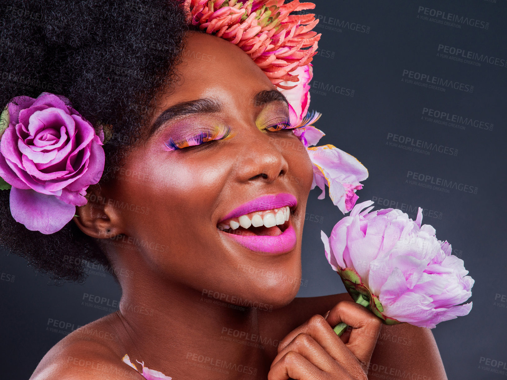 Buy stock photo African, woman and cosmetics with flowers, smile and confidence for makeup, skincare and wellness in studio. Female person, pose and happy for fashion, style and luxury in grey background for beauty
