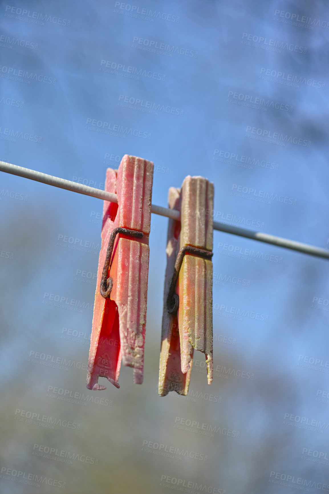 Buy stock photo Plastic material decay, crack and discoloration on household objects caused by UV radiation. Closeup details of old pegs on a clothing line outdoors against blurred background with copy space