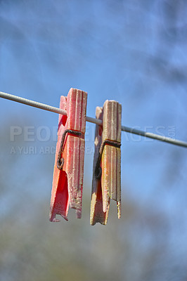 Buy stock photo Plastic material decay, crack and discoloration on household objects caused by UV radiation. Closeup details of old pegs on a clothing line outdoors against blurred background with copy space