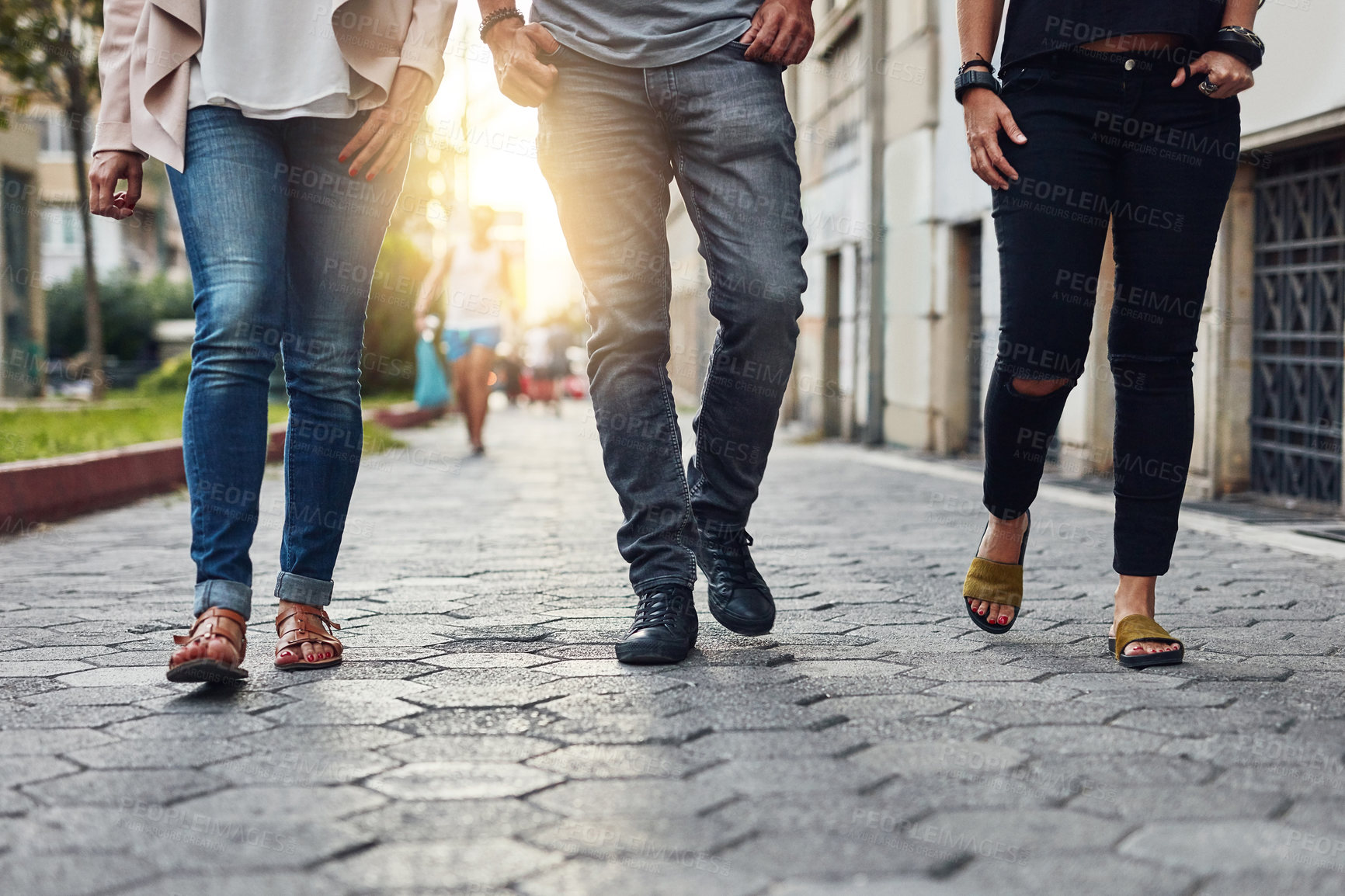 Buy stock photo Cropped shot of three people walking together in the city