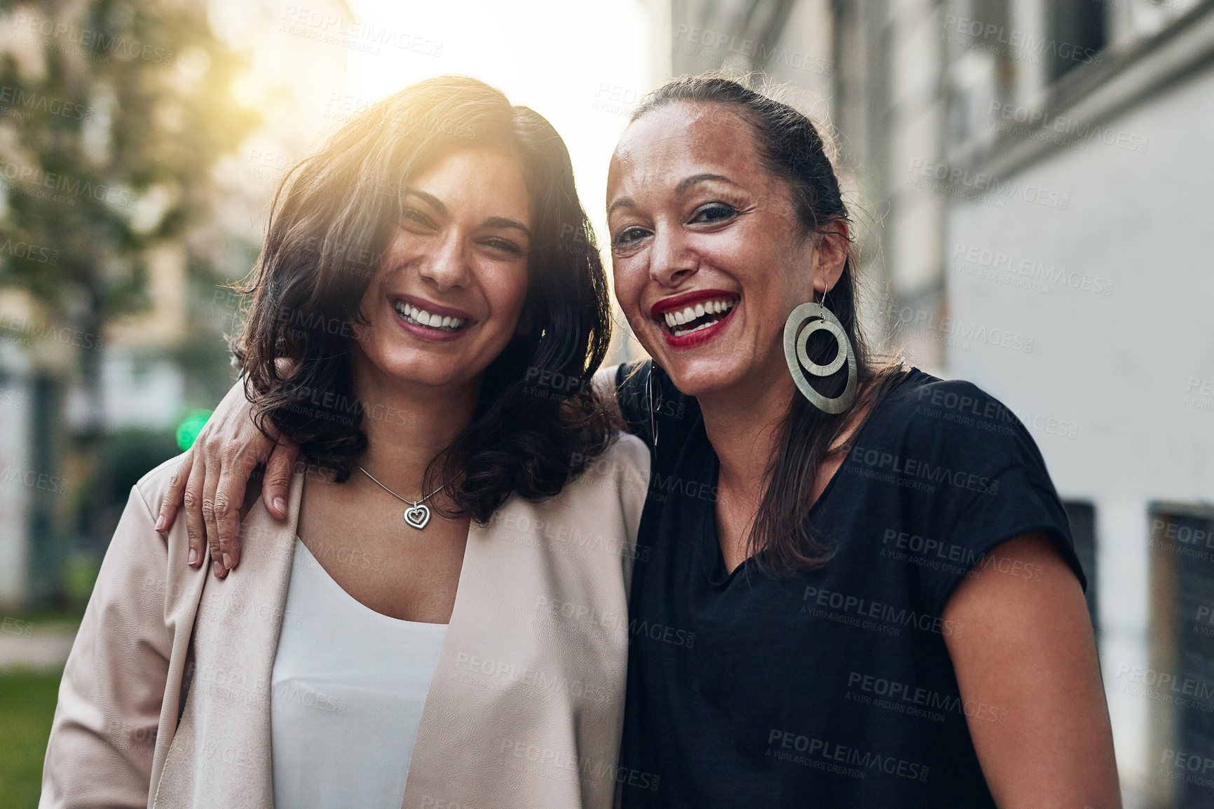 Buy stock photo Cropped shot of two friends posing together while out in the city