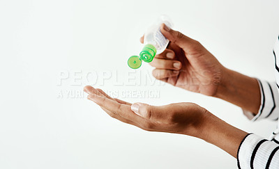 Buy stock photo Cropped shot of a woman using hand sanitiser against a white studio background