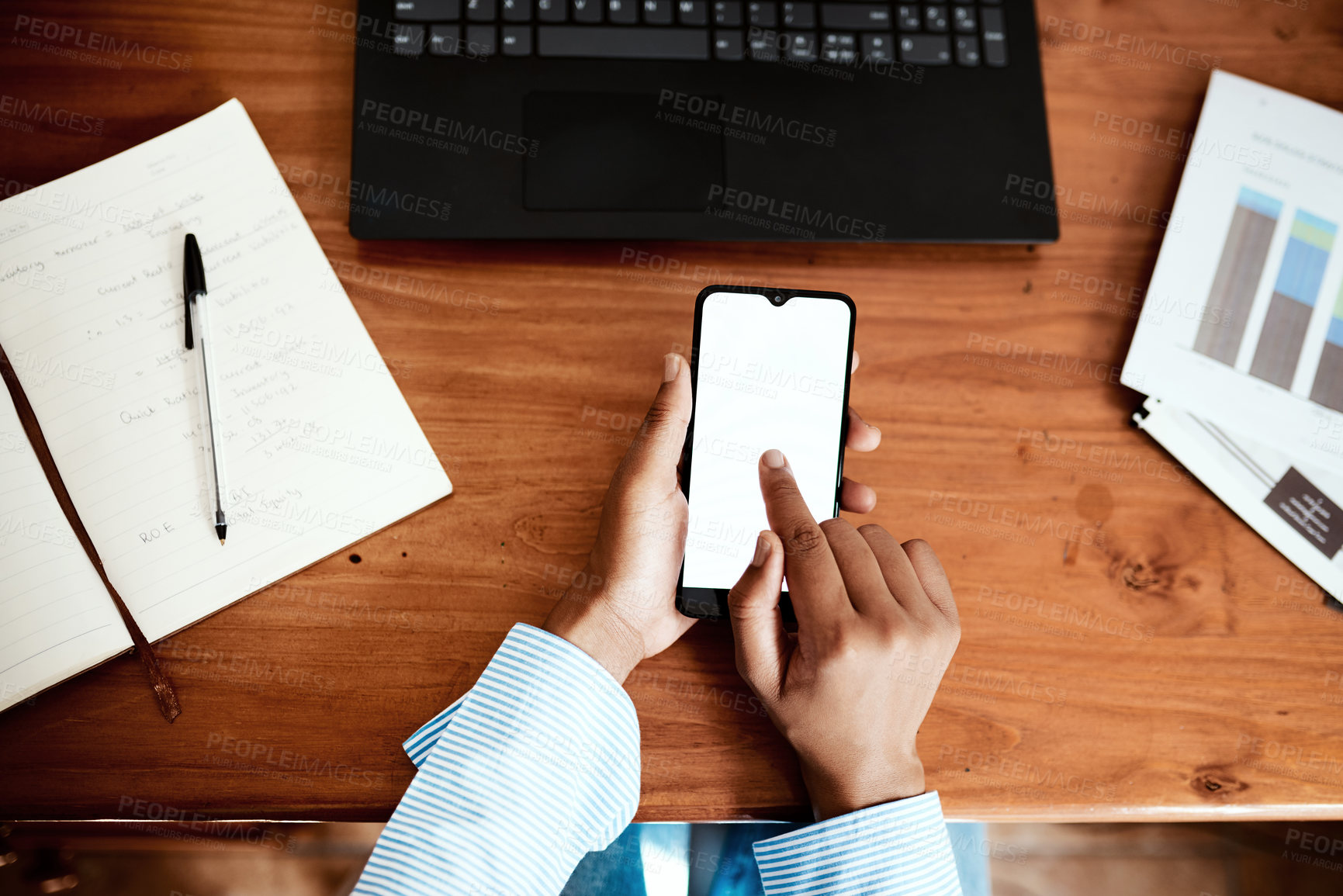 Buy stock photo Cropped shot of a businesswoman using a smartphone while going over financial paperwork at her desk