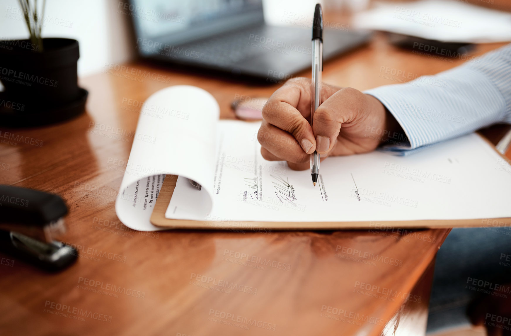 Buy stock photo Cropped shot of a businesswoman filling out paperwork at her desk