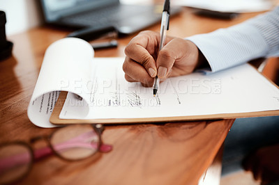 Buy stock photo Cropped shot of a businesswoman filling out paperwork at her desk