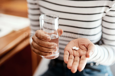 Buy stock photo Cropped shot of a woman taking her medication at home