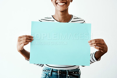 Buy stock photo Cropped studio shot of a woman holding a blue poster against a white background