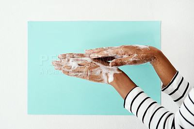 Buy stock photo Cropped shot of a woman washing her hands with soap against a studio background