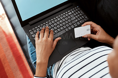 Buy stock photo Cropped shot of a woman using a laptop and credit card on the sofa at home
