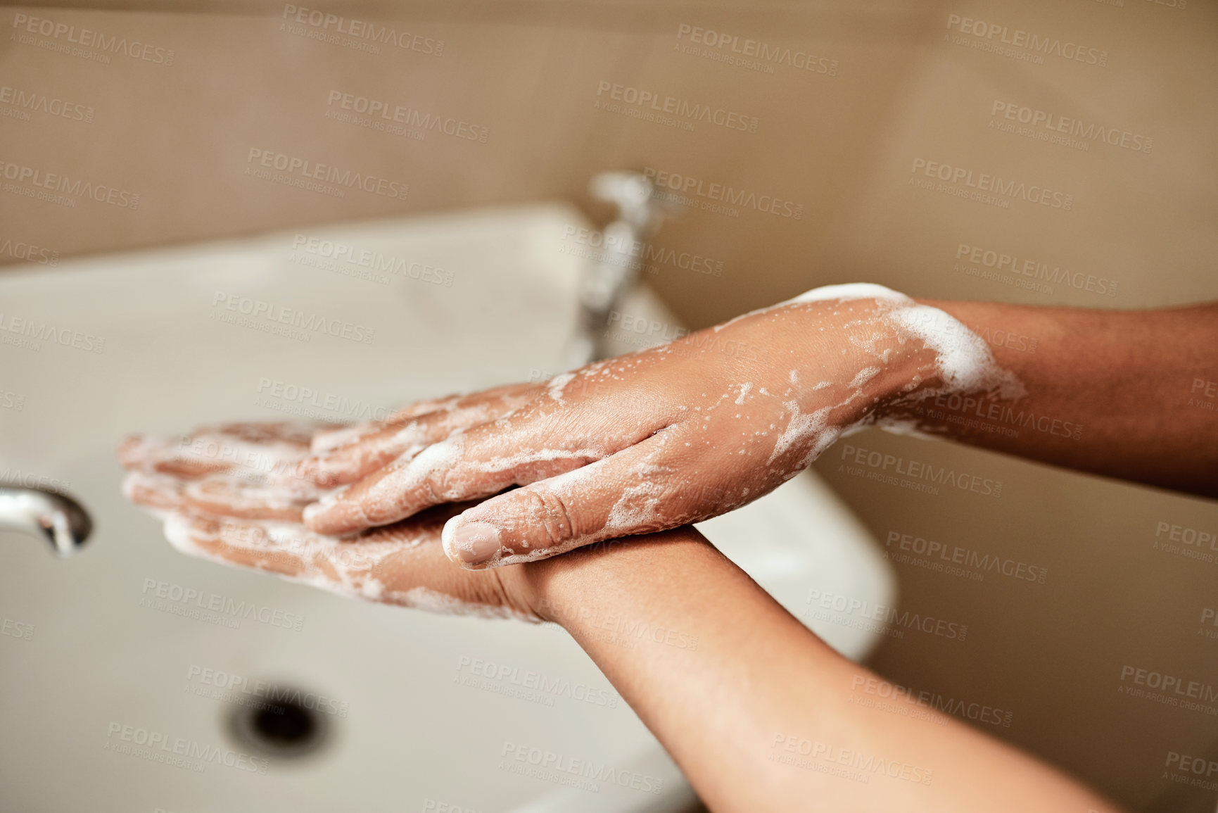 Buy stock photo Cropped shot of a woman washing her hands with soap in the bathroom sink at home