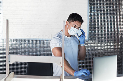Buy stock photo Shot of a young man wearing a face mask while working in a gym
