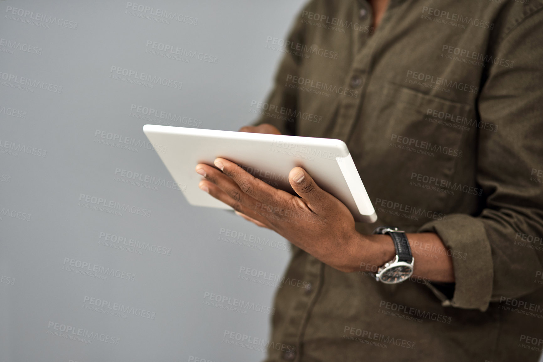 Buy stock photo Studio shot of an unrecognisable businessman using a digital tablet against a gray background