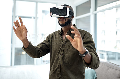 Buy stock photo Shot of a young businessman using a virtual reality headset in a modern office