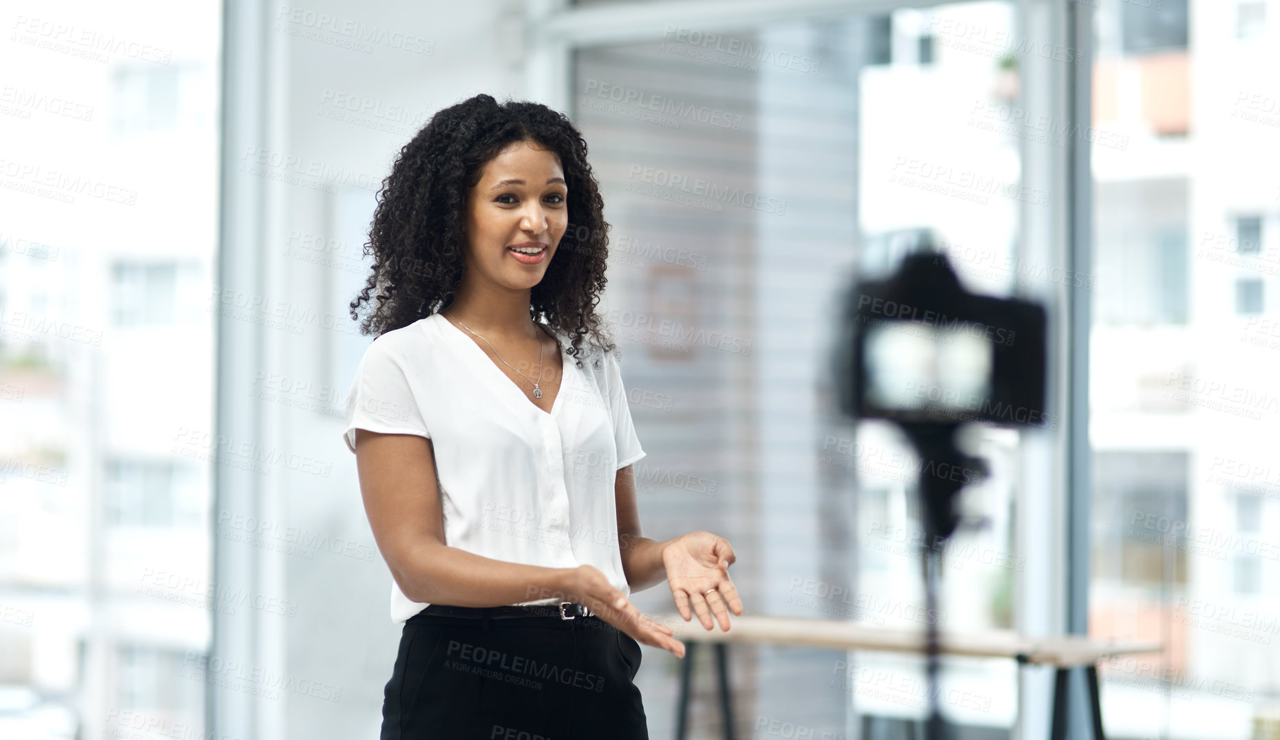 Buy stock photo Shot of a young businesswoman using a camera to record a video of herself speaking