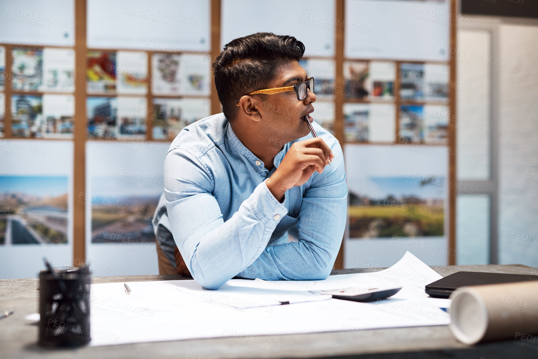 Buy stock photo Shot of a young architect designing a building plan in a modern office