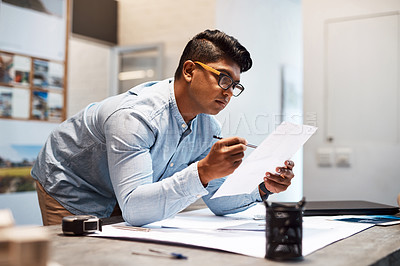 Buy stock photo Shot of a young architect designing a building plan in a modern office