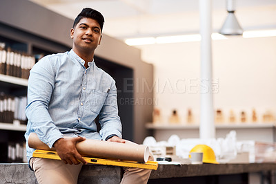 Buy stock photo Portrait of a young man holding a blueprint and spirit level in a modern office