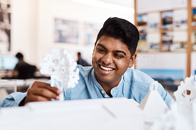 Buy stock photo Shot of a young architect designing a building model in a modern office