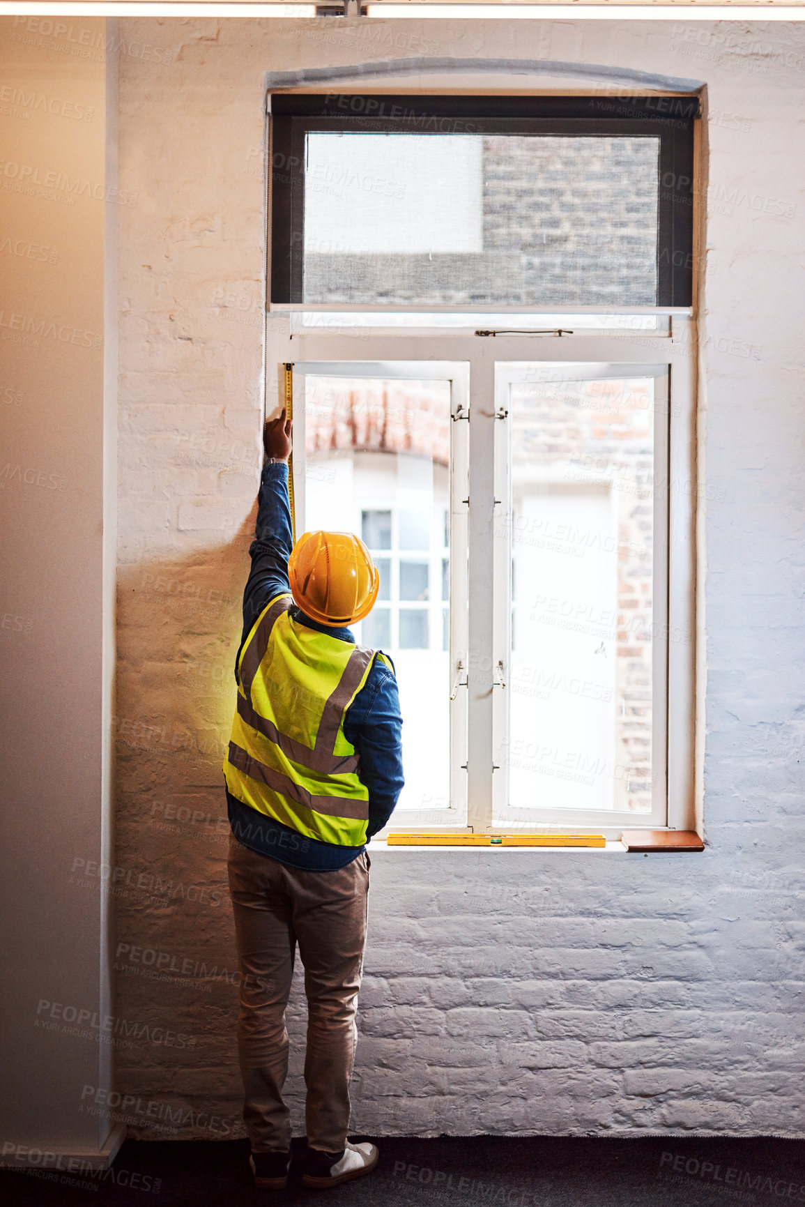 Buy stock photo Architect, person and tape measure on window for construction, renovation or maintenance with back view. Engineer, tools and check building size, frame inspection and height accuracy for home repairs