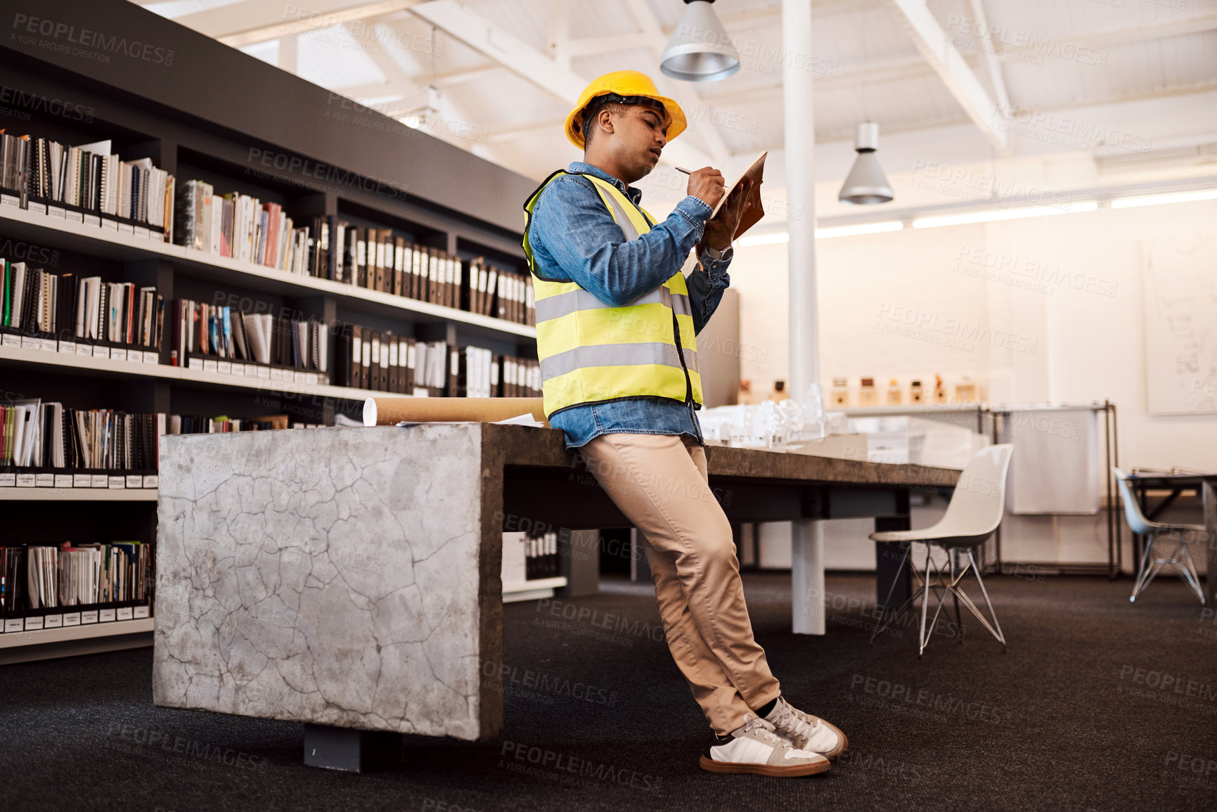 Buy stock photo Shot of an architect making notes while standing in his office