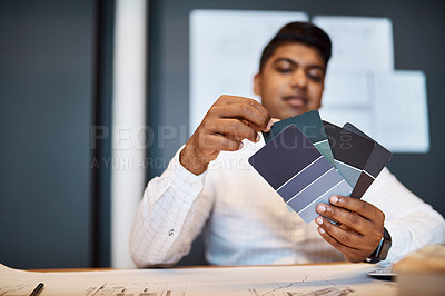 Buy stock photo Shot of a young architect deciding on a colour scheme while working on a project