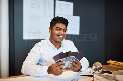 Buy stock photo Shot of a young architect deciding on a colour scheme while working on a project