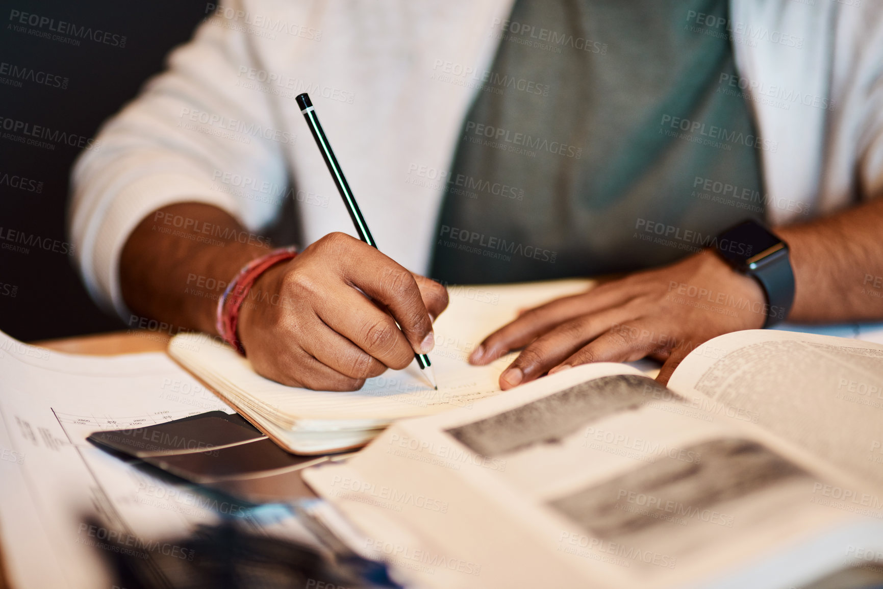 Buy stock photo Shot of an architect writing in a notebook at his desk in a modern office