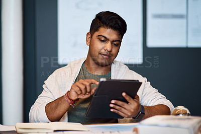 Buy stock photo Shot of a young architect using a digital tablet while drawing up a building plan