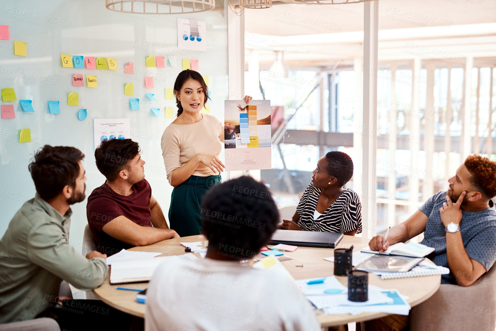 Buy stock photo Shot of a group of young creatives having a meeting in an office