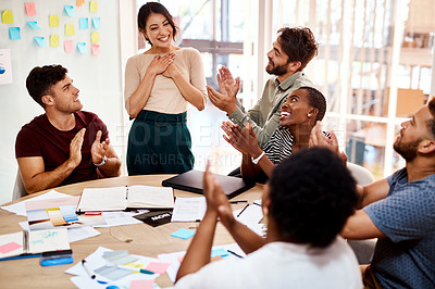 Buy stock photo Shot of a group of young creatives applauding a colleague during a meeting in an office