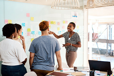 Buy stock photo Shot of a young businesswoman brainstorming with her colleagues in an office