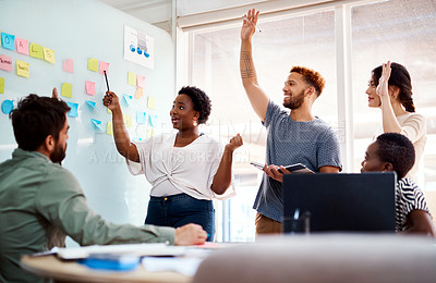 Buy stock photo Shot of a group of young creatives brainstorming together in an office