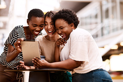 Buy stock photo Shot of a group of businesswomen using a digital tablet together in an office