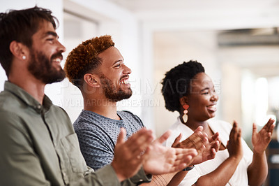 Buy stock photo Shot of a group of young creatives applauding in an office