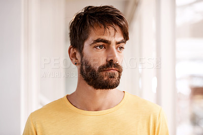 Buy stock photo Cropped shot of a handsome young male designer looking thoughtful while standing in his office